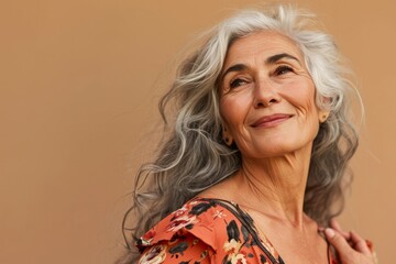 Wall Mural - Portrait of a beautiful senior woman on a beige background.