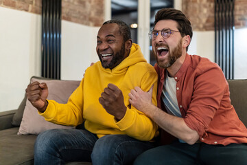 Wall Mural - Two friends watching tv and looking excited and emotional