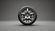 3D rendering of a single car wheel with a tire on a gray background. The wheel is made of silver-colored alloy and has a complex 5-spoke design.