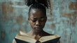 A sad black teenage girl is reading a black book on a plain white background with copy-space for text.