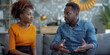 © Andrii Zastrozhnov - A married black couple engages in a therapy session, discussing their relationship issues.
