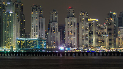 Wall Mural - Dubai Marina skyline night timelapse as seen from island in Dubai, UAE.