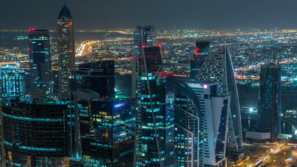 Wall Mural - Dubai business bay towers illuminated at night timelapse. Rooftop view of some skyscrapers and new towers under construction.