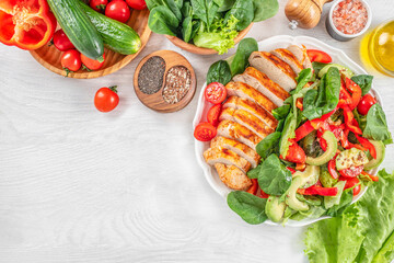 Wall Mural - Grilled chicken breast, fillet and fresh vegetable salad of tomatoes, cucumbers and leaves. Healthy food. Flat lay