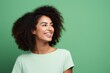 Portrait of happy african american young woman on green background