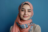 Fototapeta Panele - Portrait of smiling woman in hijab on blue background