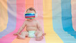 Friendly and modern diaper baby in headphones and virtual reality glasses on soft color background.