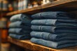 Rows of folded denim jeans on wooden shelf