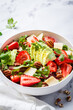 Strawberry and avocado salad with arugula, parmesan, nuts and lemon zest.