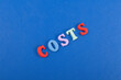 costs word on blue background composed from colorful abc alphabet block wooden letters, copy space for ad text. Learning english concept.