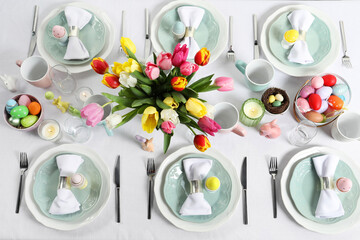 Wall Mural - Easter celebration. Festive table setting with beautiful flowers and painted eggs, flat lay