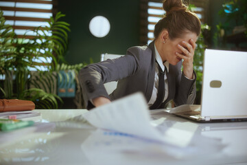 Wall Mural - sad woman worker in green office throwing documents