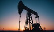 © Andrey - Oil pumps in the winter field at sunset. Oil industry equipment.