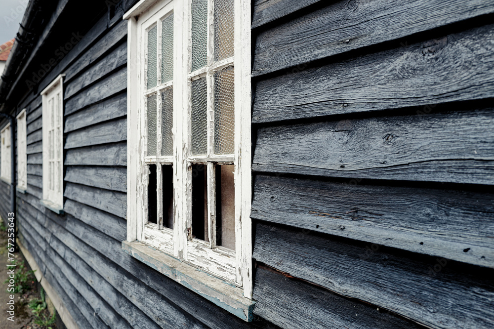 Old English wooden former Inn now derelict in a village location. The ...