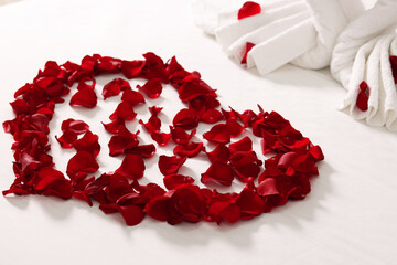 Wall Mural - Honeymoon. Heart made with rose petals on bed, closeup