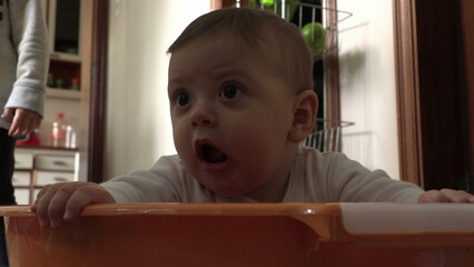 Wall Mural - Cute baby infant inside plastic laundry bucket looking up