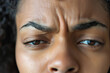 A close-up shot of a person face, their brow furrowed in pain. The focus is on the face, capturing the discomfort of a headache.