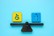 Inclusion concept. Scales with the sign of a person with disabilities and an ordinary employee.