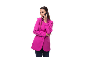 Wall Mural - young slender office worker woman with black hair dressed in a lilac jacket communicates using a smartphone