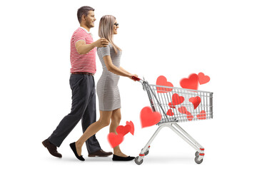 Canvas Print - Profile shot of a young couple walking and pushing a shopping cart with red hearts inside