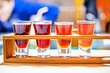 tasting of colorful fruit and berry liqueurs on a wooden stand on a craft background. Making homemade tinctures and liqueurs
