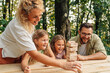 © Zamrznuti tonovi - Family is playing fun wood block board game in nature.