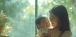 Close up portrait of beautiful young Asian mother hugs and caresses her little son against window at home. Mother's day concept, Healthcare, love, happy family, lifestyle. Copy space. child care