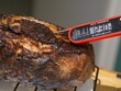 Smoked and grilled beef eye of round pulled from the heat to rest, thermometer shows 123 F