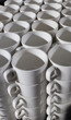 Many white coffee cups are stacked in a pile, pattern