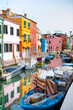 Burano island. Beautiful colored houses, canal with blue boats on water. Sunny day in the city. no peoples.