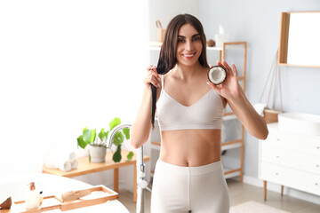 Wall Mural - Beautiful young woman with coconut in bathroom