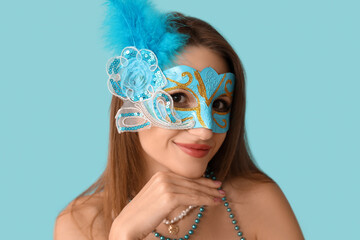 Canvas Print - Beautiful young woman in carnival mask on blue background