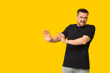 Poster - Handsome ashamed young man on yellow background