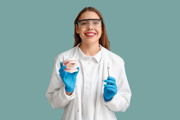 Wall Mural - Female dentist with dental tool and jaw model on blue background. World Dentist Day