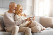 © Prostock-studio - Affectionate couple using tablet on couch