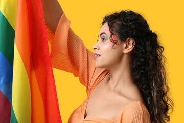 Poster - Young African-American woman with rainbow flag on yellow background. LGBT concept