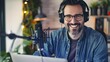 © Irina Ukrainets - Smiling Man Podcasting with Microphone and Headphones. Casual Home Recording Studio. Content Creator Lifestyle. Engaging Radio Host Portrait. AI