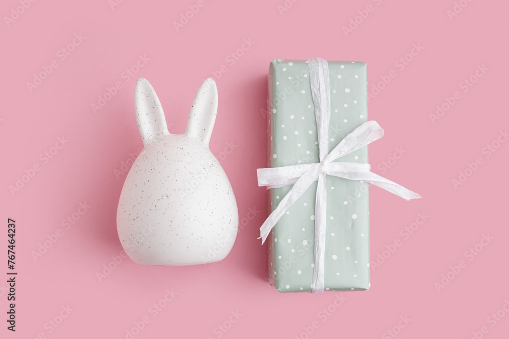 Gift box with Easter bunny on pink background