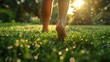 A photo of a person walking barefoot on a dewy lawn after a morning mow. 