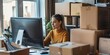 Woman on laptop surrounded by cardboard boxes running drop shipping ecommerce retail shipping business