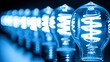 © Olga - a row of light bulbs sitting next to each other on top of a black table with blue lights in the background.
