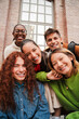 © Jose Calsina - Vertical portrait of a group of friends having fun and smiling together. High school students looking at camera with happy expression. Young friendly real people staring front posing for a photo