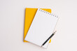 Flat lay, yellow notebook wish list with pencil on white background