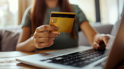 Wall Mural - A woman is using a laptop to pay for something with a credit card.