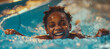 Happy african american child girl laughing and sliding down a blue water slide in aquapark