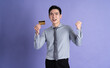© Q88 - Portrait of Asian male businessman posing on purple background