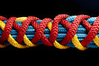 Red, blue and yellow ropes on black background. colored twisted rope made of durable material close-up. nautical rope