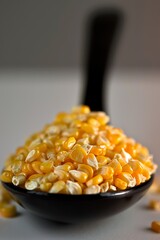 Wall Mural - A spoonful of corn is shown in a black bowl