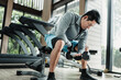 © Charnchai saeheng - A man doing exercises biceps with dumbbell  in gym. Fitness, workout and traning concept.