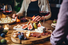Friends Having A Wine Tasting Party In A Rustic Winery, With Varieties Of Cheeses And Figs On A Beautifully Decorated Table